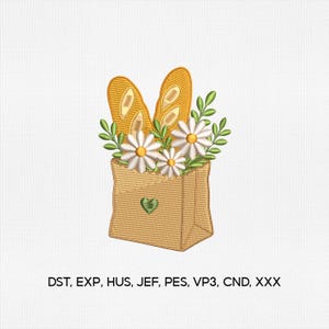 Puede incluir: Un diseño de bordado que muestra una bolsa de papel color canela con un pequeño corazón verde, que contiene dos baguettes doradas, margaritas blancas con centros amarillos y hojas verdes. El texto DST, EXP, HUS, JEF, PES, VP3, CND, XXX aparece debajo.