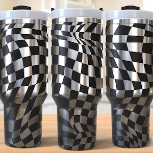 May include: Three stainless steel travel mugs with a black and silver checkered flag design. Each mug has a black handle, a white lid, and a black top. The words "SEAMLESS DESIGN" are printed on the bottom right.