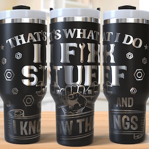 May include: Black stainless steel travel mug with a silver design that says "That's what I do I fix stuff and I know things".