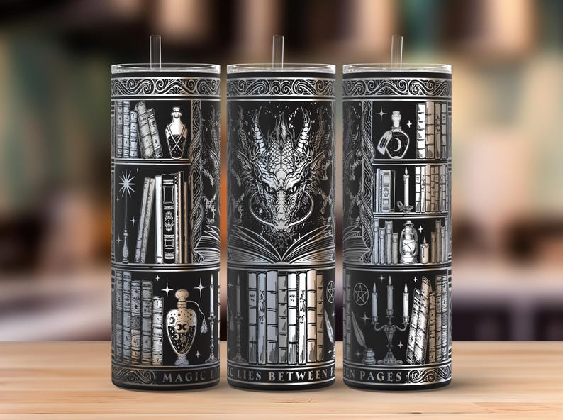 May include: Three black and silver insulated tumblers with a fantasy theme. Each tumbler features a different design: a bookshelf, a dragon, and a bookshelf with candles. The text "MAGIC LIES BETWEEN PAGES" is printed on the bottom.