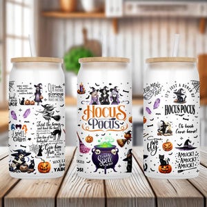 K&ouml;nnte beinhalten: Drei wei&szlig;e isolierte Becher mit schwarzen Deckeln und Bambusstrohhalmen. Jeder Becher zeigt ein anderes Halloween-Design mit schwarzen Katzen, Hexen, K&uuml;rbissen und dem Text "Hocus Pocus".