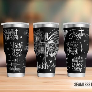 May include: Three black stainless steel tumblers with silver lids. Each tumbler features white text and graphics, including crosses, butterflies, and floral designs. The text includes phrases like "Simply Blessed" and "Faith Over Fear."