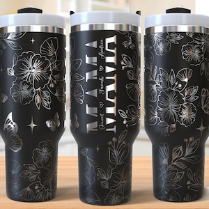 May include: Black stainless steel travel mug with a floral and butterfly design and the text "Mama" with names "Janet & Sarah" and "Andrea" engraved on the side.