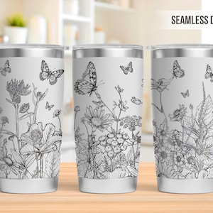 Puede incluir: Tres vasos de acero inoxidable con fondo blanco y un diseño en blanco y negro de mariposas y flores. El diseño es continuo y envuelve todo el vaso.