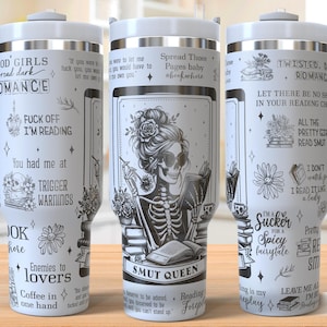 Puede incluir: Taza de viaje de acero inoxidable blanca con un diseño en blanco y negro que presenta un esqueleto leyendo un libro. La taza tiene un asa y el texto "SMUT QUEEN" está impreso en la parte delantera. La taza está rodeada de otros libros y flores.