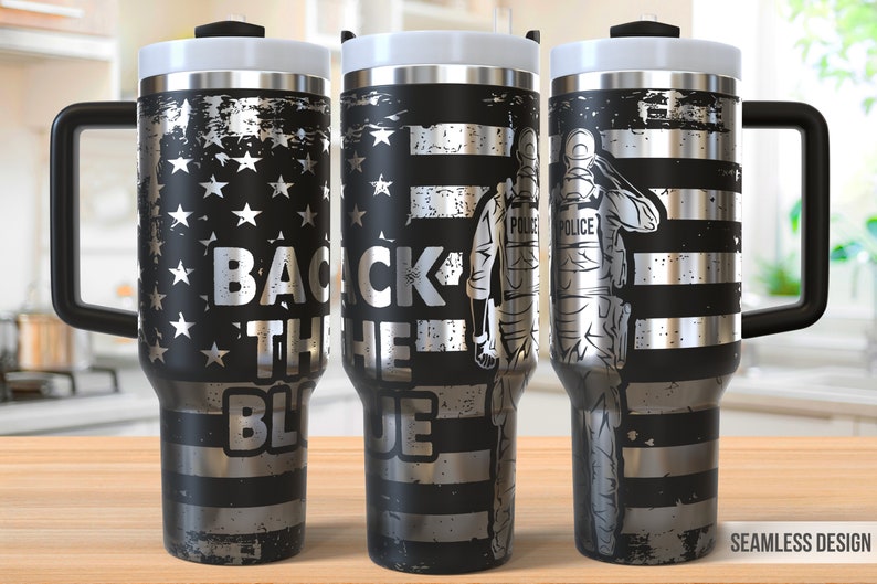 May include: A black and silver stainless steel tumbler with a handle. The tumbler features a distressed American flag design with the words "Back the Blue" and a silhouette of a police officer saluting.