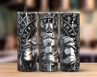 Puede incluir: Tres vasos negros y plateados con temática vikinga con pajitas. Cada vaso presenta una ilustración detallada de un guerrero vikingo sosteniendo una espada, rodeado de símbolos rúnicos. El diseño es de estilo monocromático detallado.
