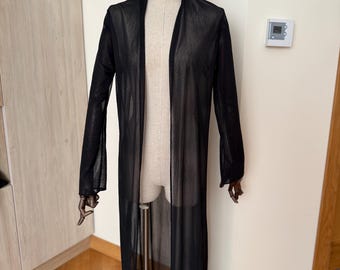 May include: A long, sheer black duster cardigan featuring an open front design, long sleeves, and a lightweight, semi-transparent fabric with a subtle shimmering texture. The garment hangs straight down to the floor, providing a layered look.