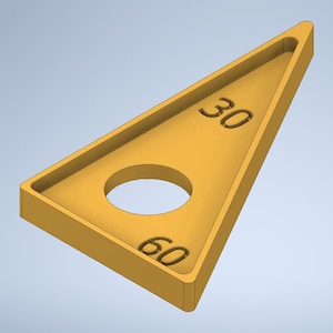 Può includere: Un triangolo di plastica giallo con un foro al centro e i numeri 30 e 60 stampati su di esso.