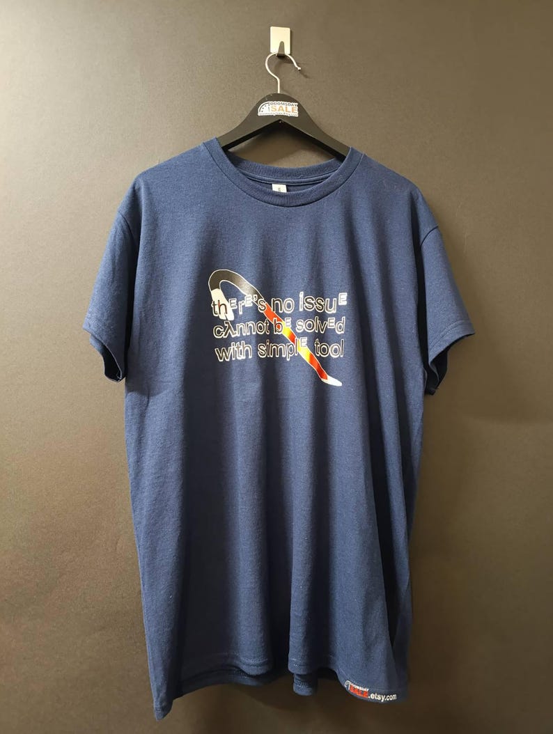 May include: A navy blue t-shirt with a white graphic of a wrench with the text "there's no issue cannot be solved with simple tool".