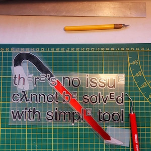 May include: A red and black vinyl sticker with the text "there's no issue cannot be solved with simple tool" on a green cutting mat.