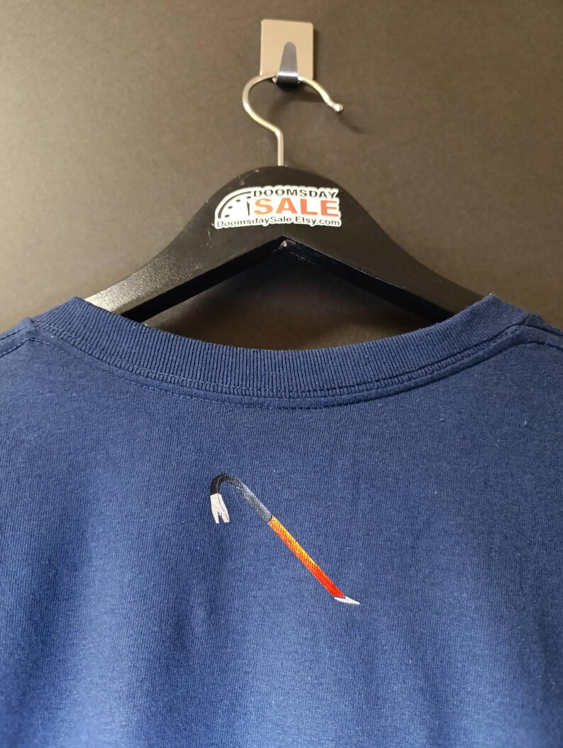 May include: A navy blue t-shirt with an embroidered crowbar design. The t-shirt is hanging on a black hanger with a white tag that says "Doomsday Sale" and "DoomsdaySaleEtsy.com".