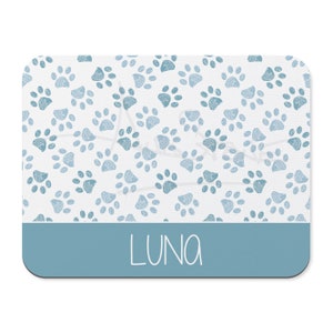 May include: A blue and white mouse pad with a paw print pattern and the name "LUNA" in white text.