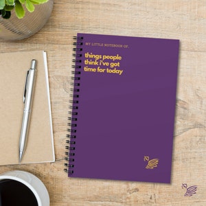 K&ouml;nnte beinhalten: Lilafarbener Spiralblock mit dem Text "MY LITTLE NOTEBOOK OF... things people think I've got time for today" in gelber Schrift.