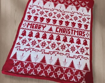 Puede incluir: Una manta navideña de ganchillo roja y blanca. La manta presenta las palabras "MERRY CHRISTMAS" en el centro, rodeadas de árboles de Navidad, campanas y patrones de copos de nieve. La manta es rectangular y tiene un borde rojo.