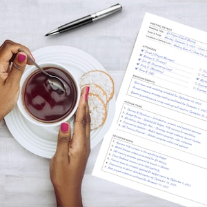 May include: A meeting agenda with handwritten notes, a pen, a cup of tea, and crackers. The agenda includes meeting details, attendees, announcements, agenda items, and decisions made. The pen is silver and black.