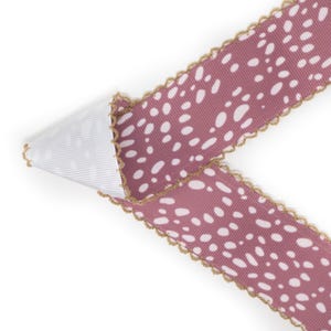 Peut inclure: Ruban d&eacute;coratif mauve &agrave; pois blancs, bord&eacute; d'une bordure dor&eacute;e festonn&eacute;e. Le dessous du ruban est blanc et c&ocirc;tel&eacute;. Ce ruban est adapt&eacute; aux travaux manuels, &agrave; l'emballage de cadeaux et &agrave; d'autres fins d&eacute;coratives.