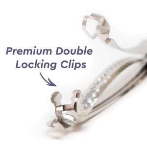 May include: Close-up of a silver double locking clip. The clip has a textured surface and a double locking mechanism.  Premium Double Locking Clips.