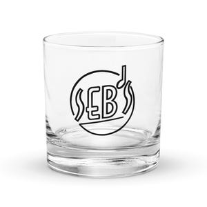 May include: A clear glass tumbler with a black and white logo that says "£B's" with a musical note above the letters. The logo is inside a circle with a wavy line on each side.