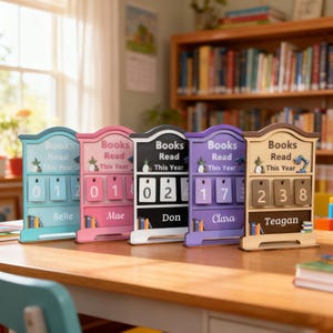 May include: Five colorful wooden book counters with the text "Books Read This Year." Each counter displays a different number of books read, with names like Belle, Mae, Don, Clara, and Teagan. The counters are on a wooden table.