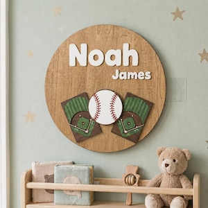 May include: A circular wooden wall sign featuring the name Noah James in white 3D lettering. Below the name, a central white baseball with red stitching is flanked by two rectangular wooden plaques depicting green baseball field diagrams.