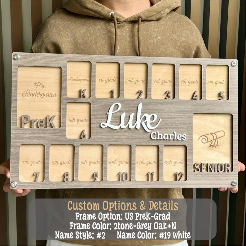 May include: A personalized wooden school years board with spaces for Pre-K through 12th grade, plus a Senior section. The board is gray with a light wood interior, featuring the name "Luke Charles" in white. Includes laser-cut numbers and grade labels.