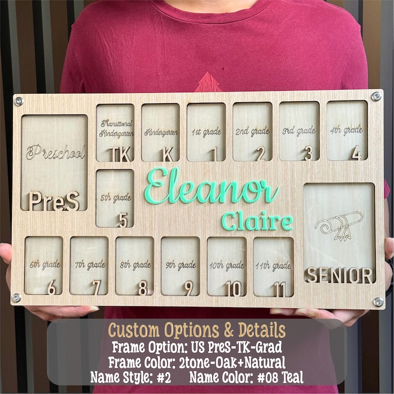 May include: A wooden school years photo display with slots for preschool through 11th grade, plus a senior year slot. The name "Eleanor Claire" is in teal, with the grade levels etched into the wood. The frame is two-tone oak and natural.