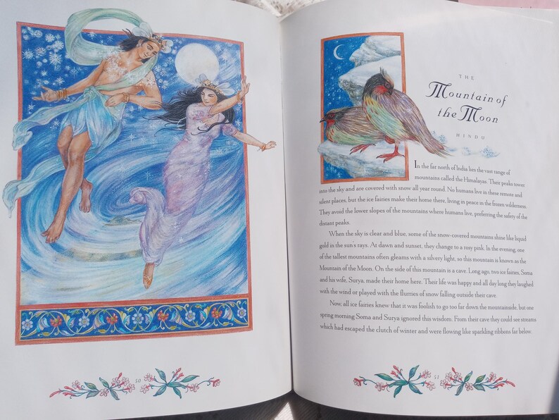 Puede incluir: Ilustraci&oacute;n en un libro abierto, que representa dos figuras con t&uacute;nicas fluidas sobre un fondo azul y blanco. La p&aacute;gina opuesta muestra una ilustraci&oacute;n de un p&aacute;jaro con el texto "The Mountain of the Moon".