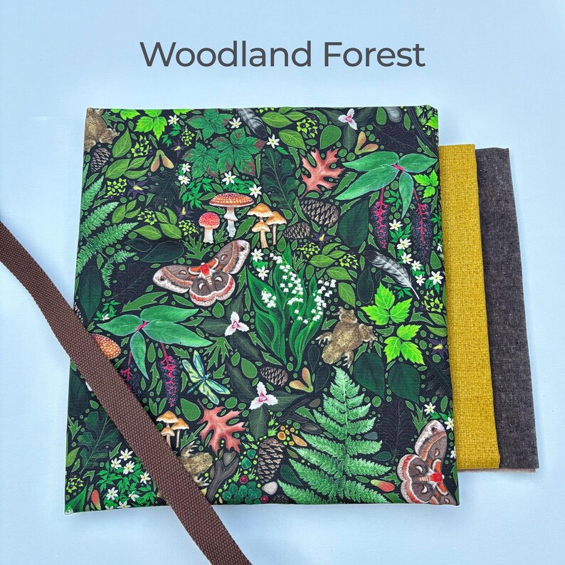 Może przedstawiać: Kwadratowy materiał z leśnym wzorem z grzybami, motylami i liśćmi. Tekst "Woodland Forest" znajduje się na g&oacute;rze. Obok trzy pr&oacute;bki materiału w kolorze ż&oacute;łtym, brązowym i szarym, z brązowym paskiem po lewej stronie.