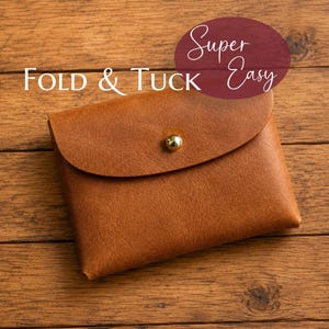 Op de afbeelding: Een bruinleren etui met een afgeronde flap en een enkele goudkleurige metalen knoopsluiting. De tekst "Super Easy" is in wit schrift gedrukt boven de tekst "FOLD & TUCK" in witte hoofdletters, gepositioneerd over het etui.