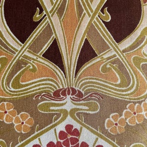 Puede incluir: Primer plano de una tela con un dise&ntilde;o Art Nouveau. El patr&oacute;n presenta formas florales y org&aacute;nicas estilizadas en tonos de marr&oacute;n, beige, naranja y rojo. El dise&ntilde;o es sim&eacute;trico y detallado, con una apariencia texturizada.