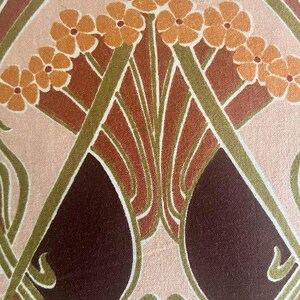 Puede incluir: Primer plano de una tela con un dise&ntilde;o floral Art Nouveau. El patr&oacute;n presenta flores estilizadas en tonos naranja, marr&oacute;n y burdeos, sobre un fondo rosa claro y crema. Los tallos verdes y las l&iacute;neas curvas completan el dise&ntilde;o.
