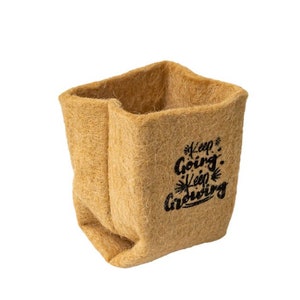 Puede incluir: Un macetero cuadrado de color beige, hecho de un material fibroso. El macetero tiene las palabras "Keep Going, Keep Growing" en escritura negra. Diseñado para plantas, es adecuado para uso en interiores o exteriores.