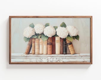May include: A painting of a white hydrangea bouquet resting on a shelf with a row of vintage books. The books are bound in brown leather with gold lettering. The painting is framed in a brown wood frame.
