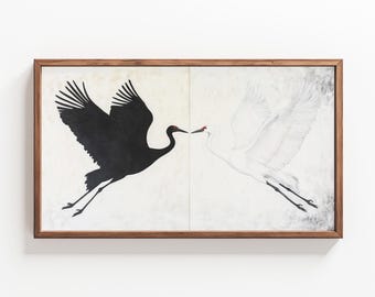 May include: A framed painting of two cranes in flight, one black and one white, facing each other. The cranes are depicted against a light background.