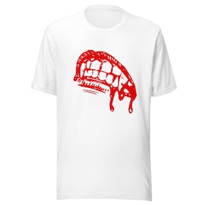 May include: White t-shirt featuring a red graphic of a vampire's mouth with fangs and dripping blood.