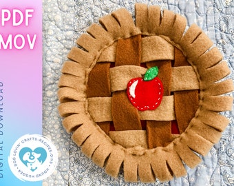 May include: A brown felt apple pie dog toy with a red felt apple and green felt leaf. The pie crust is made of brown felt strips and has a frayed edge.