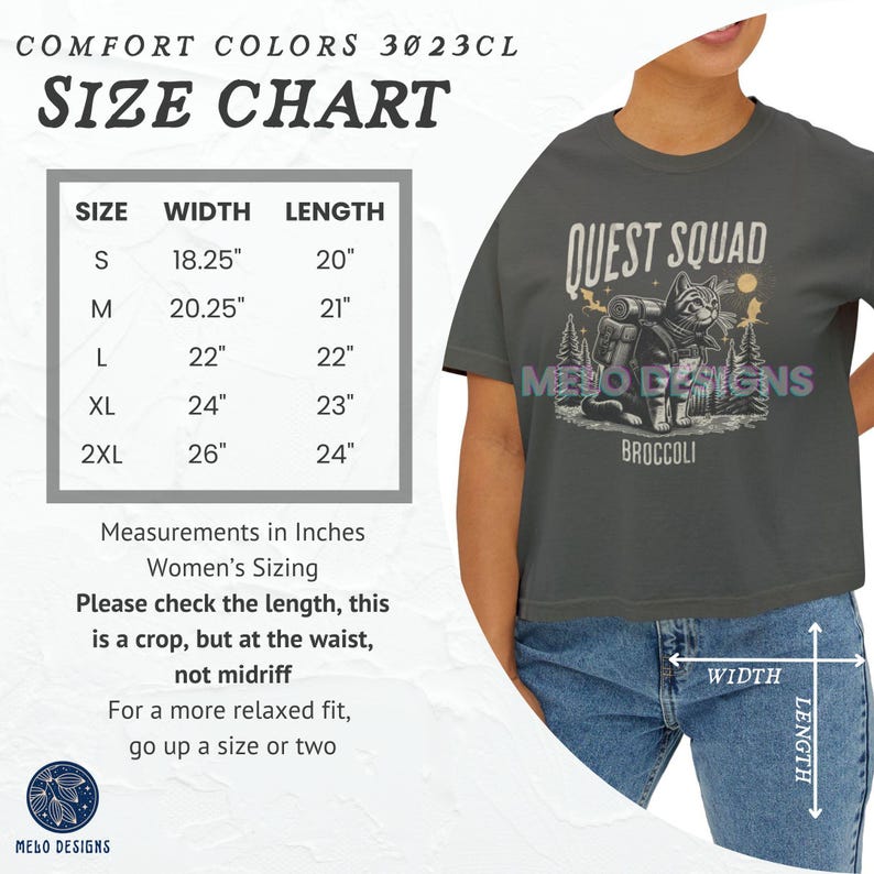 May include: Size chart for a gray cropped t-shirt with the text "Quest Squad" and a graphic of a cat wearing a backpack. The chart shows the width and length in inches for sizes S, M, L, XL, and 2XL.