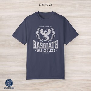 Puede incluir: Una camiseta azul marino con un gr&aacute;fico blanco de un drag&oacute;n y el texto "Riders Quadrant, Basgiath War College, Navarre".