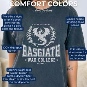 Puede incluir: Una camiseta azul oscuro con un gr&aacute;fico de drag&oacute;n blanco y el texto "Basgiath War College" en blanco. La camiseta est&aacute; hecha de 100% algod&oacute;n hilado en anillo y tiene un ajuste c&oacute;modo.