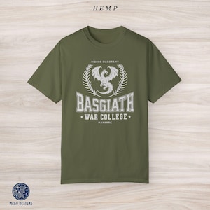 Puede incluir: Una camiseta verde con un dise&ntilde;o gr&aacute;fico blanco que presenta un drag&oacute;n, una corona de laurel y el texto "Riders Quadrant, Basgiath War College, Navarre".