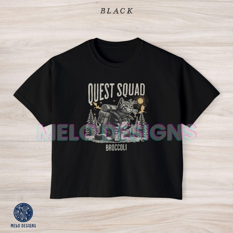 May include: Black cropped t-shirt with a graphic of a cat wearing a backpack and the text "Quest Squad" and "Broccoli".