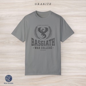 Puede incluir: Una camiseta gris con un gr&aacute;fico de drag&oacute;n negro y el texto "Riders Quadrant Basgiath War College Navarre".