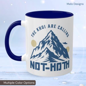 May include: White ceramic mug with a blue rim and handle. The mug features a mountain range graphic with the text "The Klui Are Calling Not-Hoth".