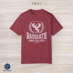 Puede incluir: Camiseta color burdeos con un gr&aacute;fico blanco de un drag&oacute;n con el texto "Riders Quadrant", "Basgiath War College" y "Navarre".