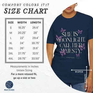 May include: A navy blue t-shirt with a size chart in inches. The shirt features a pink butterfly design and the text "She is Moonlight. Call Her Majesty." with the word "Kingfisher" below the text.