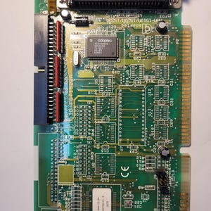 May include: A green printed circuit board featuring an Adaptec A10-63600 chip, a large black D-sub connector at the top, and various electronic components including capacitors, resistors, and integrated circuits soldered onto the board surface.