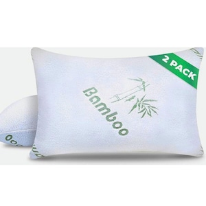 May include: Two white bamboo pillows. The pillows have a textured surface and are labeled "Bamboo" in green text with a bamboo plant illustration. A green banner indicates a "2 PACK" set.