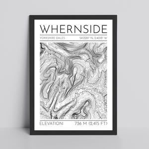 May include: Black framed print featuring a detailed topographic map of Whernside in the Yorkshire Dales. The print includes the name, coordinates, and elevation of 2,415 feet. The map is in black and white.