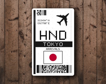 Może przedstawiać: Biała karta pokładowa z czarnym tekstem i czerwonym kółkiem z białym kółkiem w środku. Tekst brzmi "HND TOKYO ARRIVALS" i "35.5494° N 139.7798° E".
